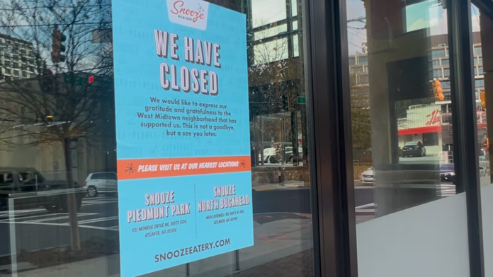 Closure sign posted on the window of Snooze Eatery in West Midtown Atlanta